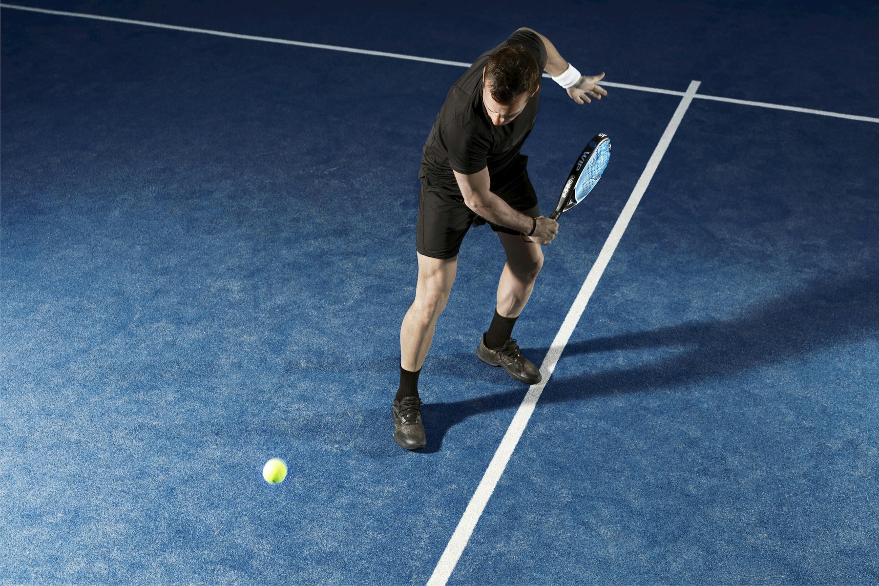 A padel player moving towards the ball